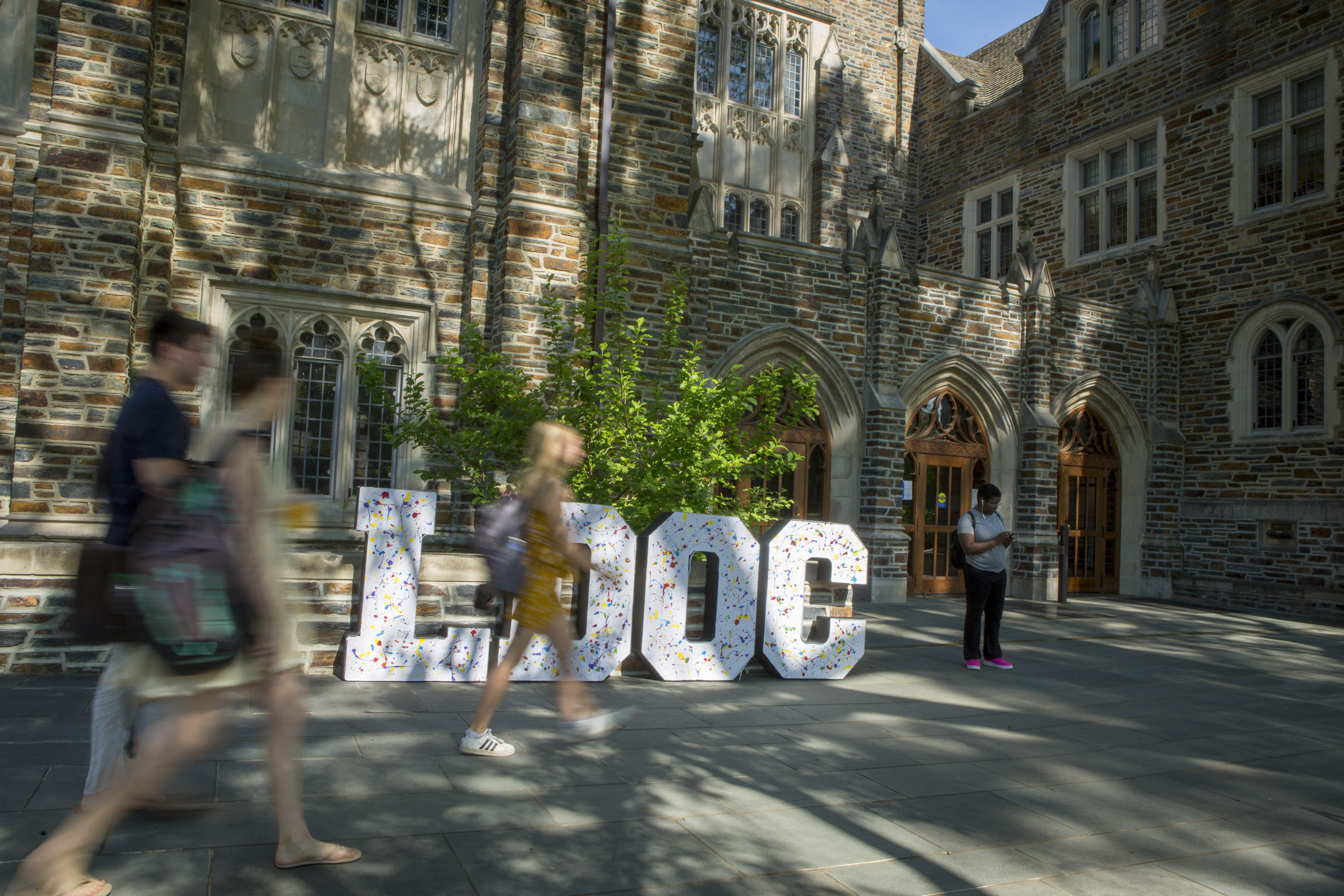 Large letters spelling LDOC in front of Perkins Library with people passing by