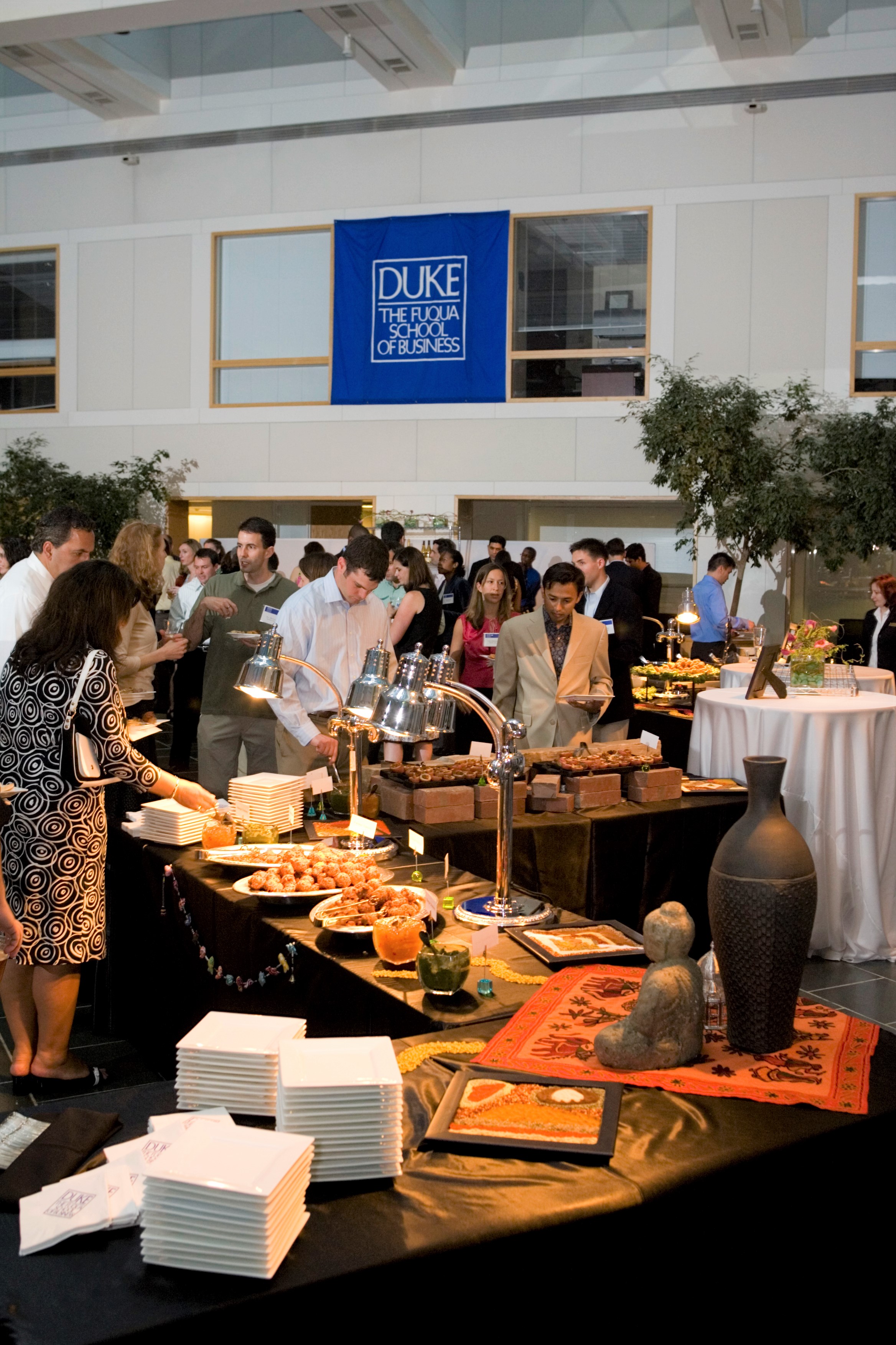 A photo of a decadent evening buffet stretching across the Fox Café while Fuqua Reunions participants enjoy dinner and socialize nearby
