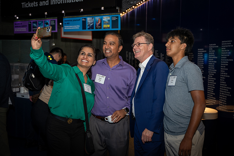 Four Duke alumni taking a selfie at an event.