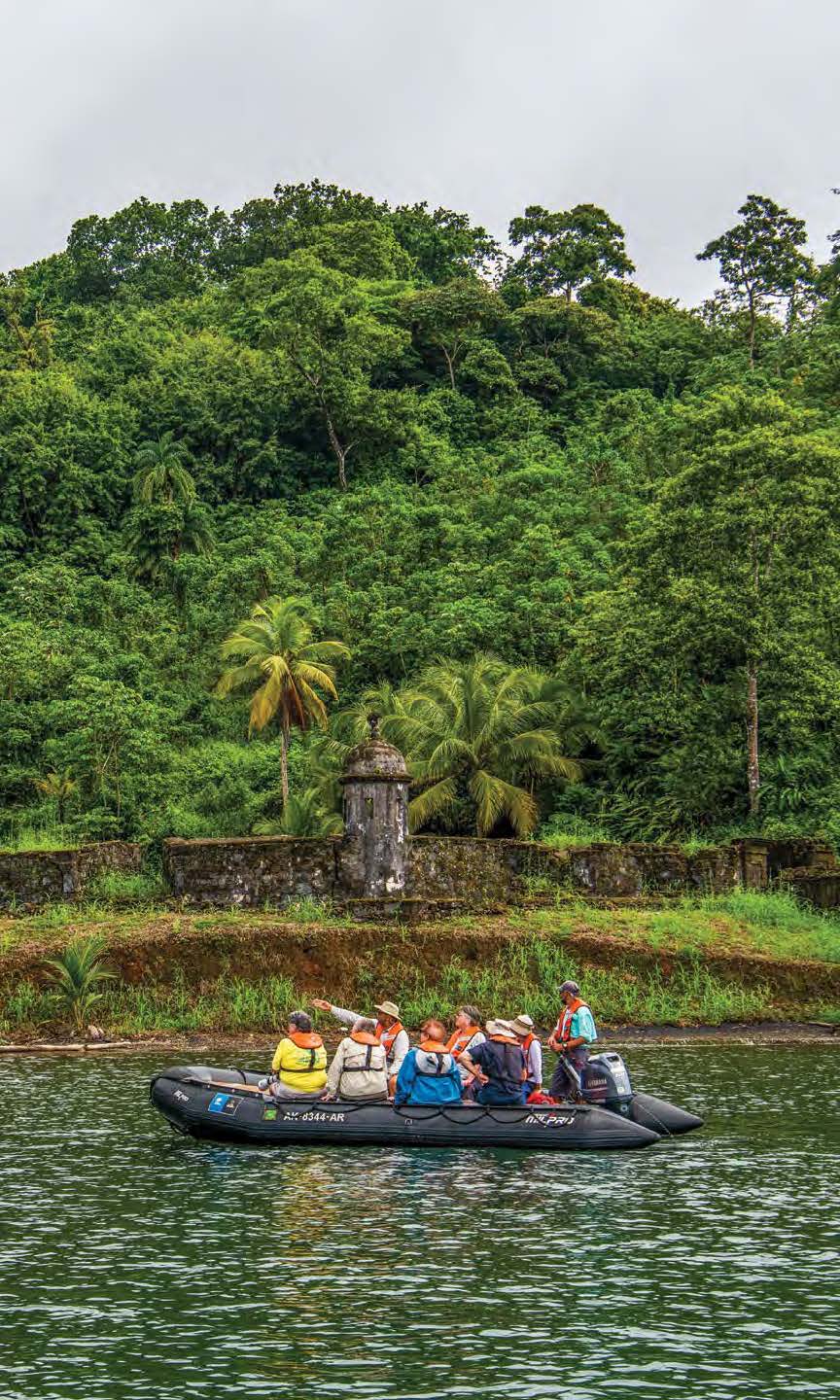 People traveling down river in a blow up raft.
