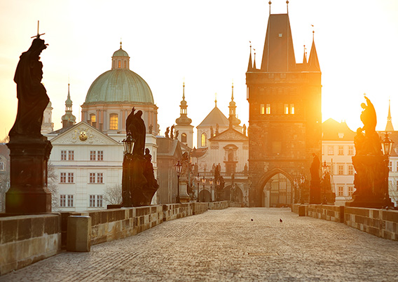 Street and buildings of Prague with sun setting in the background
