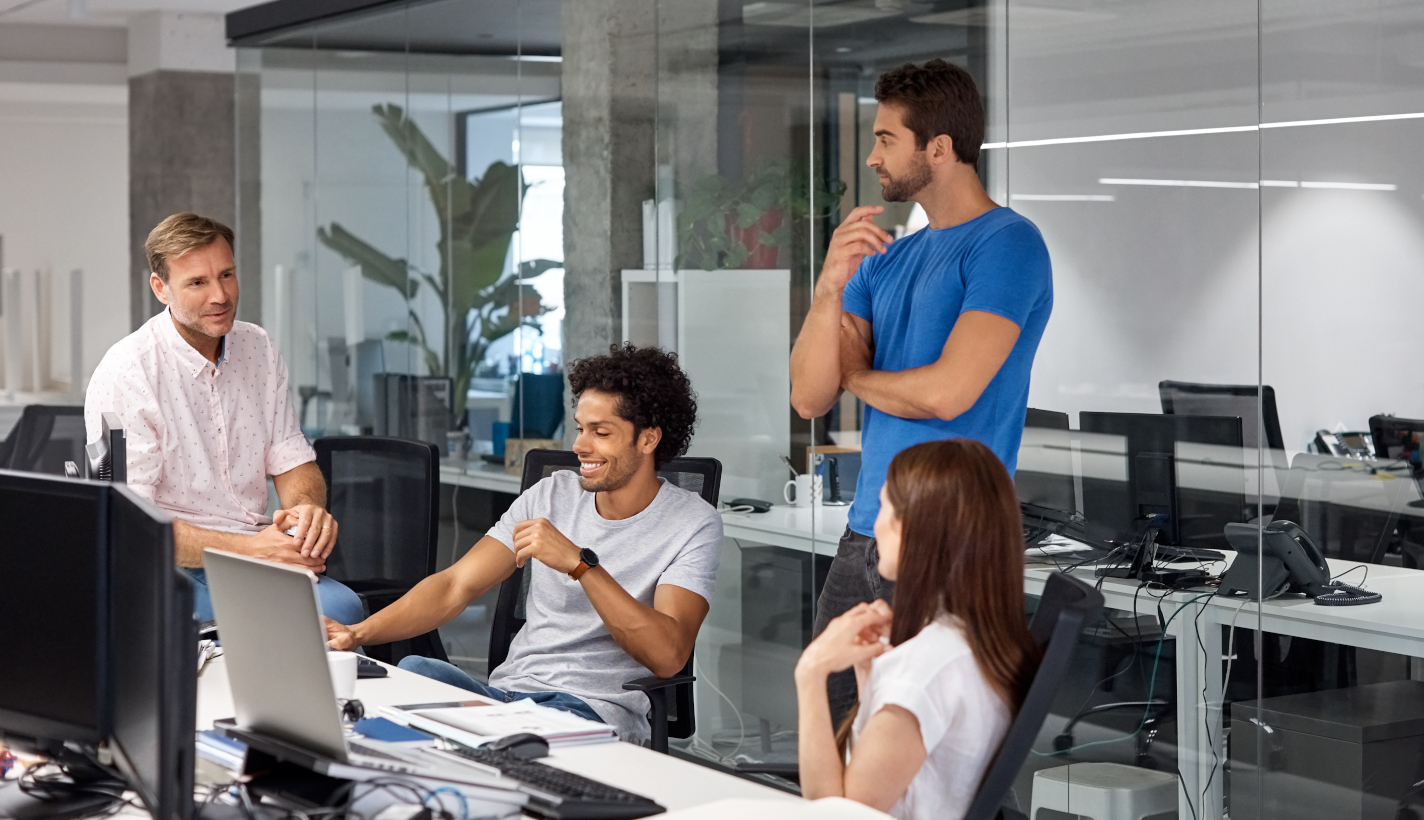 People standing in an office settling looking at a computer together.