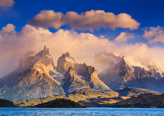 cloud covered mountains with sea in foreground