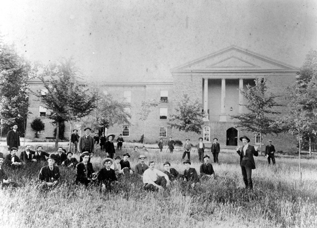 old black and white photo of alumni in front of a building